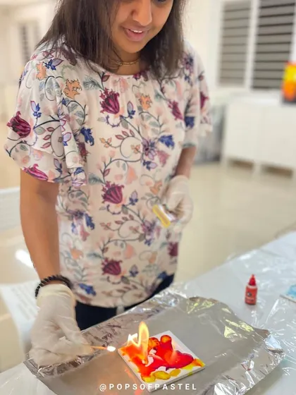 This participant is using a flame to create unique effects in her alcohol ink art, a technique for more advanced students.