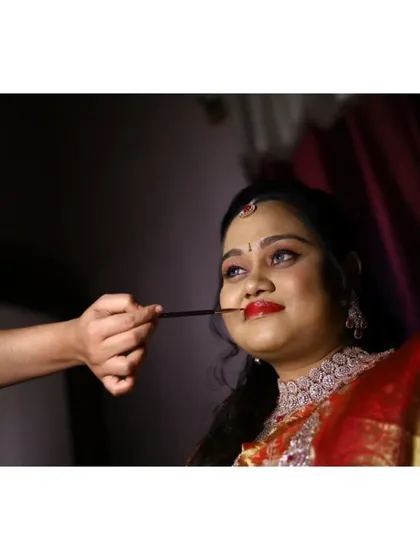 The final touches are just as important as the first. This candid moment captures me perfecting the bride's bold red lip for her reception, ensuring every detail is flawless before she makes her entrance.
