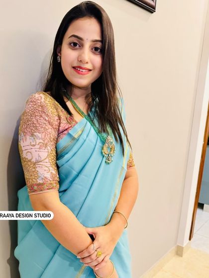 A client in a beautiful light blue saree. Her custom blouse features intricate embroidery on the sleeves, adding a touch of elegance to her look.