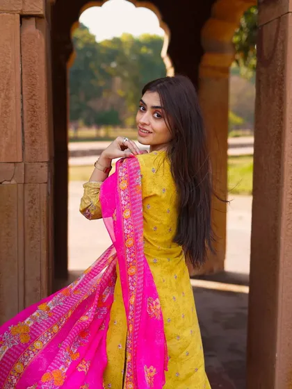 An over-the-shoulder glance with a flowing dupatta. This classic pose is always elegant and effective for showcasing the back details and drape of an outfit.