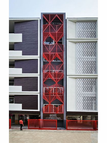 A full frontal view of the "R.E.D" building, showing the central red staircase core.