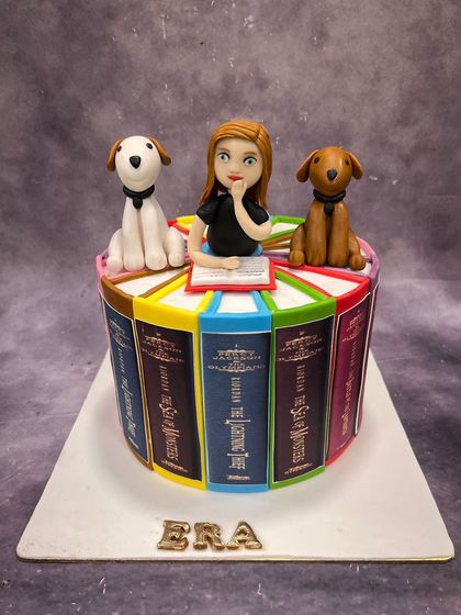 This cake is a book lover's dream. We designed it to look like a stack of colorful classic novels, complete with a fondant figurine of the birthday girl reading with her two adorable dogs.