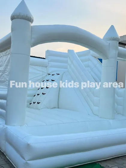 A three-quarter view of the white castle, showcasing its full structure from the jumping area to the slide exit.