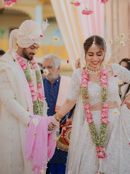 The couple takes their first steps as husband and wife, showered in petals.