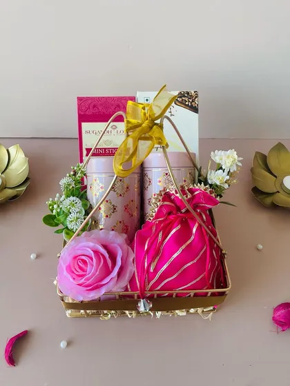 A top-down view of the pink and gold metal basket hamper. The combination of colors and textures makes it a luxurious gift.