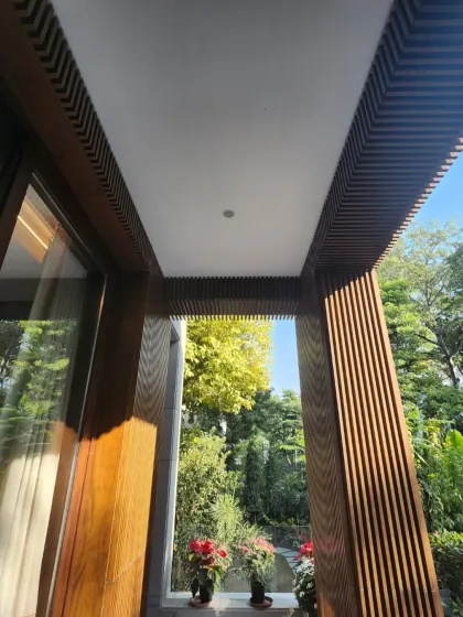 The deep overhangs and wooden screens on this facade are not just aesthetic. They are functional elements that sculpt the light, casting soft glows and shadows that shift throughout the day, making the building feel alive.