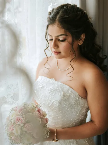 A close-up portrait through the window. The soft focus adds a dreamy quality to the image, highlighting her delicate features and soft makeup.