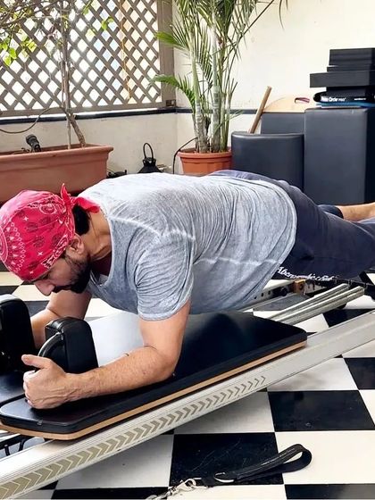 Saif Ali Khan proves that real men do Pilates. Here he is holding a strong forearm plank on the Reformer, an exercise that builds incredible core endurance and shoulder stability.