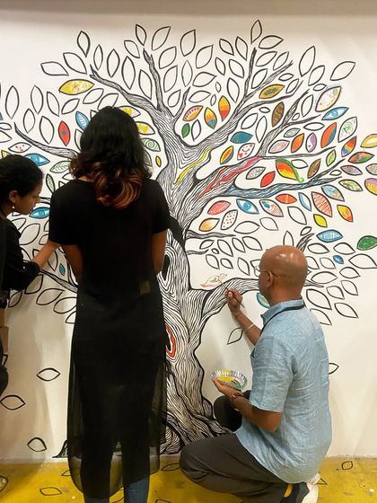 The 'Mosaic of Us' tree mural was a collaborative piece created during the Hearth Summit. I painted the outline, and attendees brought it to life by coloring in the leaves. It stands as a beautiful symbol of how individual contributions create a vibrant, collective whole.