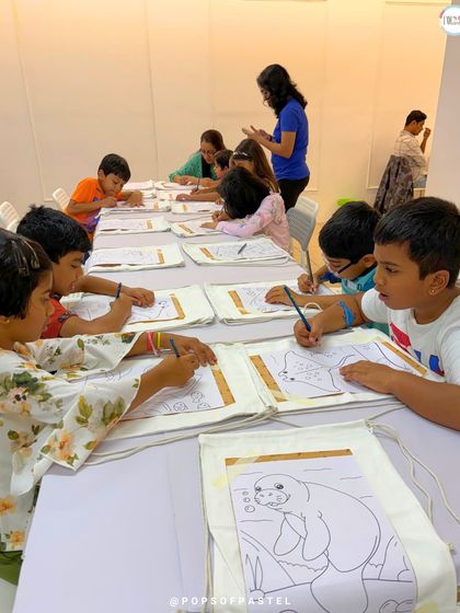 Kids at an "Under The Sea" party are focused on coloring their tote bags, a great, no-mess activity for younger guests.