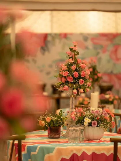 Another view of the colorful table setting, showing how the floral arrangements and patterned linens work together to create a cohesive and festive dining experience.
