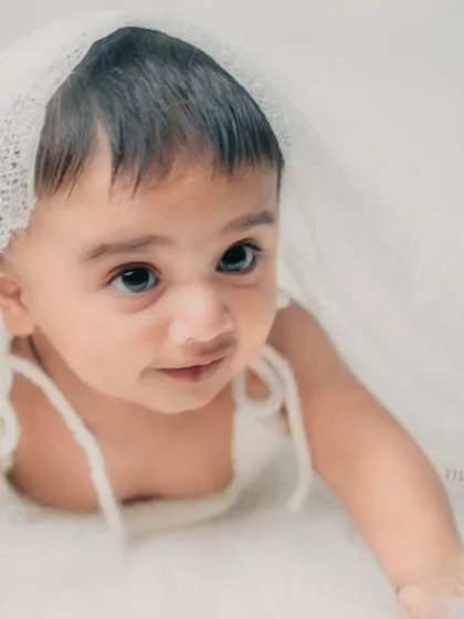Playing peek-a-boo under a delicate lace veil. This adds a touch of sweetness and fun to the photoshoot.