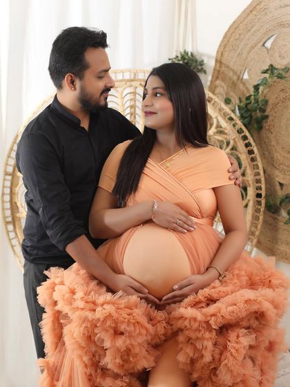 Three hearts beating as one. This intimate couple portrait captures the shared love and anticipation, with the mom-to-be looking radiant in a peach ruffled gown.
