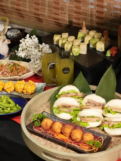 Here is another look at a full catering spread we designed for a client. It showcases the versatility of our menus, featuring pork bao buns, croquettes, and fresh salads alongside sushi and edamame, ensuring there is something for every guest to enjoy.