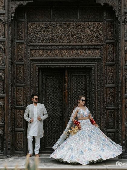 A stylish shot of a couple against a grand, intricately carved wooden door in Jaipur. I use architectural details to create dramatic and impactful pre-wedding portraits.