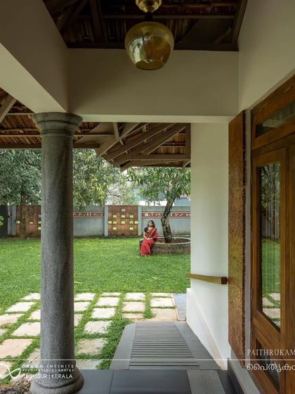 A view from the verandah into the garden, where a woman sits under a tree, capturing the tranquil and timeless quality of this heritage-inspired home.