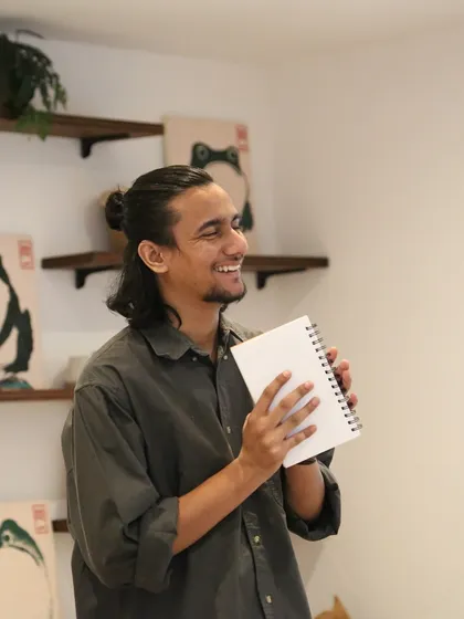 A young poet smiling after his performance at the 'Chai & Poetry' event.