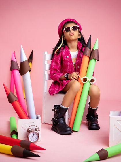 Posing with a pout, this seven-year-old is a natural model. The pink backdrop and coordinated outfit make the colors pop in this stylish shot.