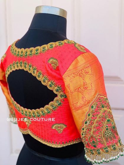 A side view of the coral blouse, showing both the detailed sleeve embroidery and the unique back cutout. The Kanchipuram fabric on the sleeve adds a traditional touch.