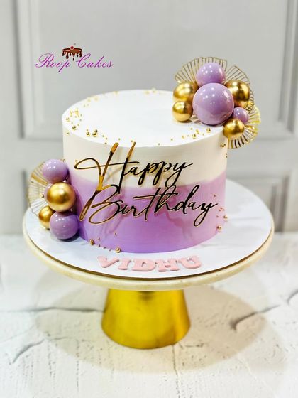 Simple yet classy. This birthday cake features a beautiful lavender and white ombre design, accented with purple and gold spheres.