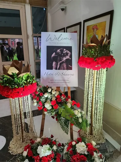 A welcome sign for Hetri and Shaurya's wedding, featuring traditional floral pillars made of jasmine and marigold strings.
