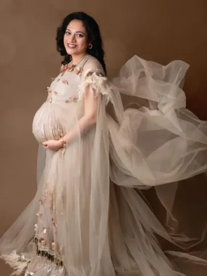 A beautiful portrait of a mom-to-be in our beige embellished gown, with the flowing fabric creating a sense of movement.