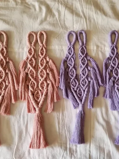 A set of our macrame curtain ties laid out, showing the intricate knot work and design. We offer them in pairs to beautifully frame your windows.