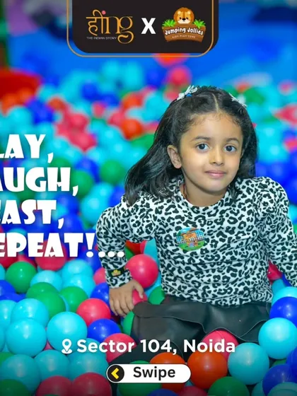 A young girl in an animal print shirt posing from inside the colorful ball pit. It's a fantastic spot for photos and endless fun.