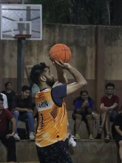 Perfect shooting form on display. A player releases a shot with the crowd looking on in anticipation.