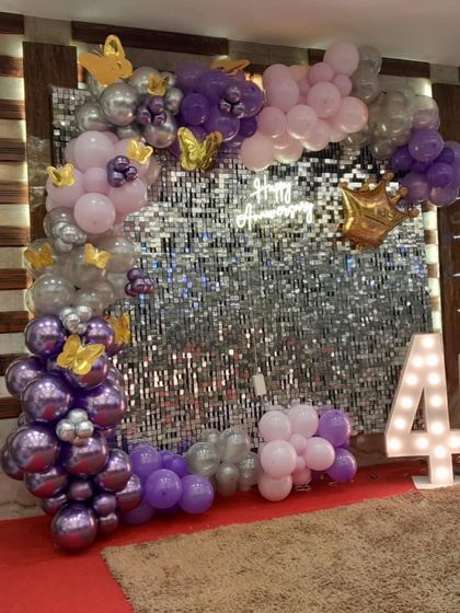 A wider view of the 40th anniversary photo corner. The asymmetrical balloon arch beautifully frames the shimmer wall, creating a stylish and modern look.
