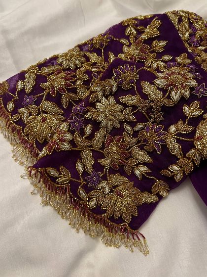 This purple net blouse was a joy to create for my dear client Sowmya's baby shower. The sheer sleeves are adorned with delicate, hand-embroidered floral vines in gold threadwork, creating a look of ethereal elegance for her special day.