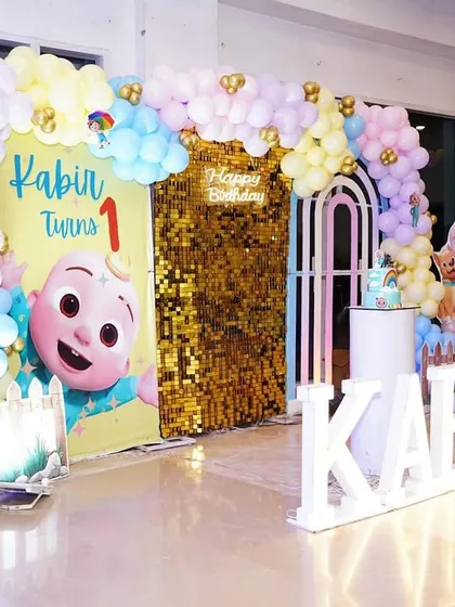A wider view of Kabir's party, showing the "LOVE" blocks and a toy car prop, adding more playful elements to the decor.