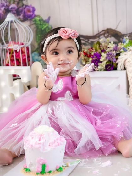 Clap for the cake! This action shot captures the excitement and anticipation of a first birthday cake smash.