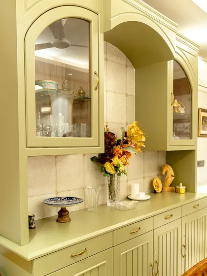 A detail shot of the bespoke crockery unit, finished in a soft sage green. The design features arched glass doors, a tiled backsplash, and classic hardware, showcasing our attention to custom cabinetry and finishing touches.