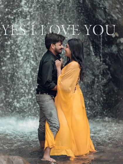 A beautiful portrait of a couple standing in a waterfall. The woman's bright yellow dress stands out beautifully against the dark rocks and white water.