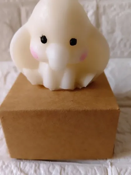A single, adorable baby elephant candle made from soy wax. This is one of my most requested items for baby shower return favors, shown here with its individual gift box.