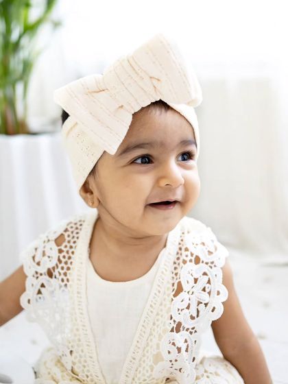 A close-up portrait from the boho-themed sitter session, highlighting her adorable smile and the cute lace details of her outfit.