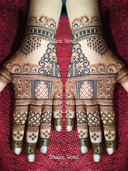 A traditional design with architectural elements and delicate 'jaal' work, covering the full hand.