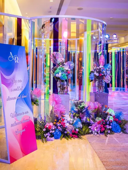 A welcome sign and vibrant floral arrangement at the entrance to the iridescent Sangeet. The sign reads "You are a wall of shimmer and shine," perfectly setting the tone for the glamorous night ahead.