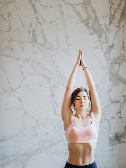 This image shows the upward stretch variation of Tadasana (Mountain Pose), which helps to elongate the spine and open the chest. It's a simple yet powerful way to improve posture and awareness.
