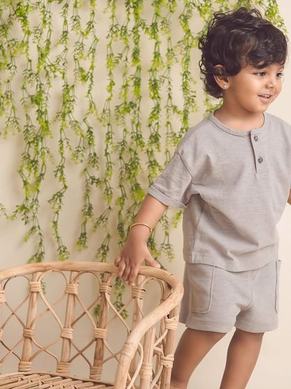 A candid shot of a toddler exploring the studio. The natural textures of the chair and greenery add a lovely touch to this kids' portrait.