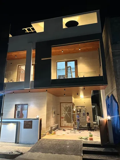A glimpse of a contemporary villa we designed, seen at dusk. The strategic lighting highlights the clean lines, wooden accents, and glass railings, creating a warm and inviting exterior that stands out.