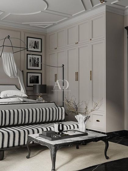 Inspired by the elegance of Art Deco and old Hollywood glamour, this bedroom features a striking black and white palette. The wrought-iron canopy bed and striped bench create a graphic and sophisticated statement.