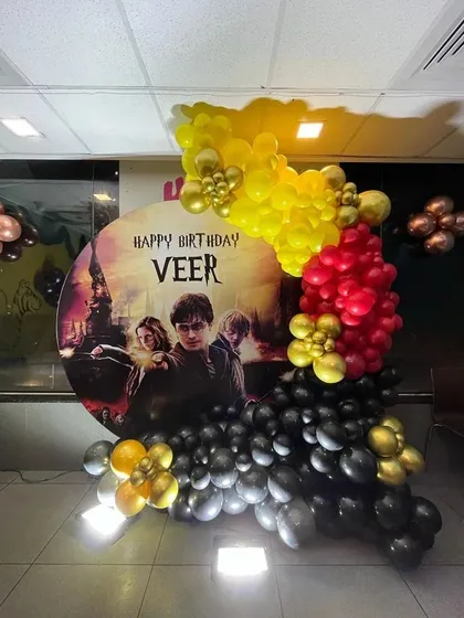 This is a duplicate of ID 26, 194, 218. A magical Harry Potter theme for a fan's birthday. This decoration includes a custom circular backdrop with the movie poster, and a balloon garland in Gryffindor colors of red, yellow, and black.