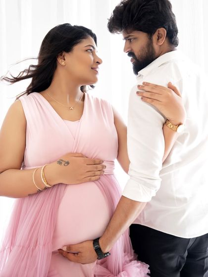 A close-up shot capturing the loving gaze between a couple as they hold the baby bump, highlighting their emotional bond.