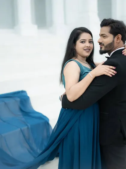 A classic portrait pose against the grand white pillars, showcasing the elegance of the couple's attire and the location.
