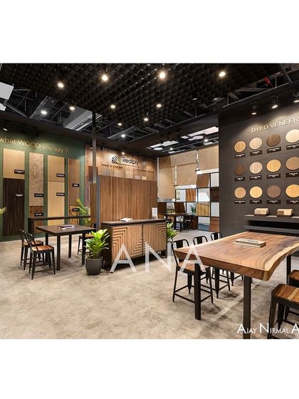 The interior of the Realply '23 booth combines product displays with functional meeting spaces. A live-edge table provides a rustic touch, contrasting with the organized sample walls for dyed and natural veneers.