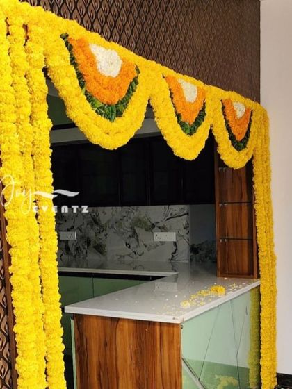 This marigold flower decoration is perfect for archways or kitchen entrances during a housewarming. The bright yellow garlands add a pop of color and traditional charm to the celebration.