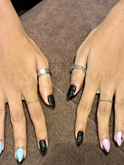 An edgy and unique set featuring a mix of black, baby blue, and pink nails with sharp, graphic line art.