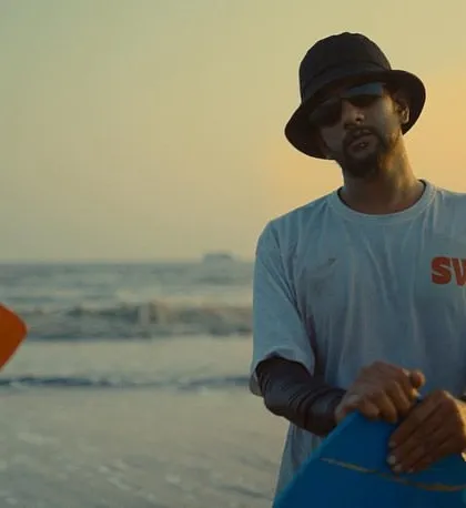 A screen grab from the "Made to Move" music video, featuring surfers at the beach during sunset. The look was natural and sun-kissed.
